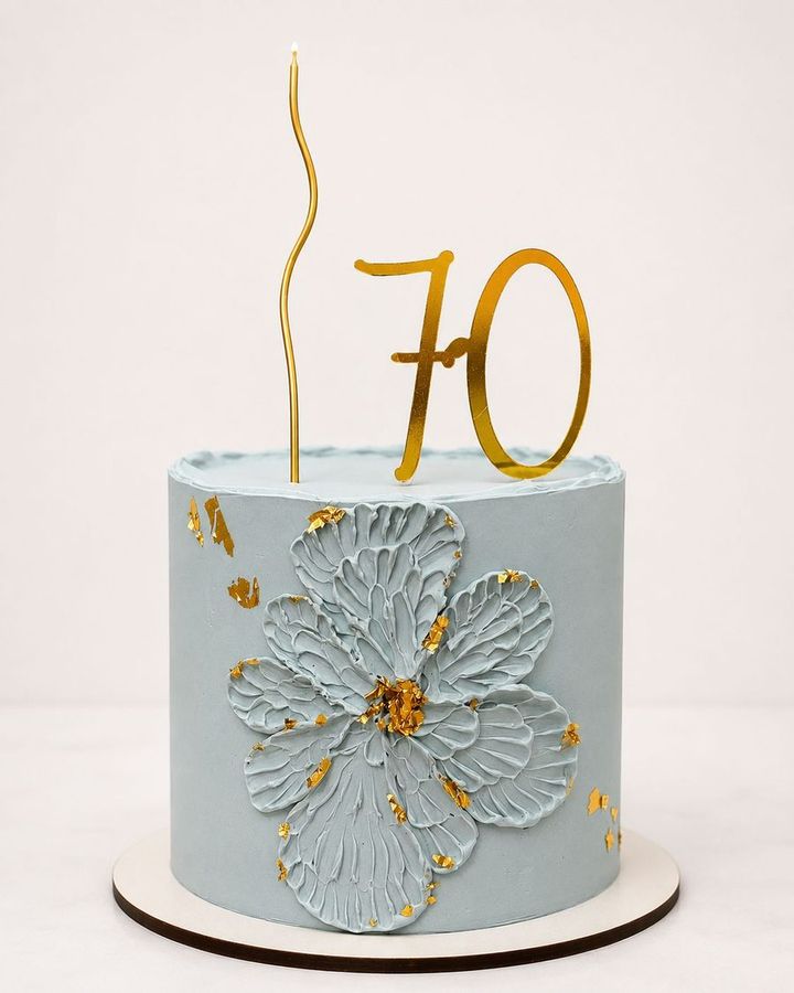 Bolo azul com flor em relevo e topo dourado